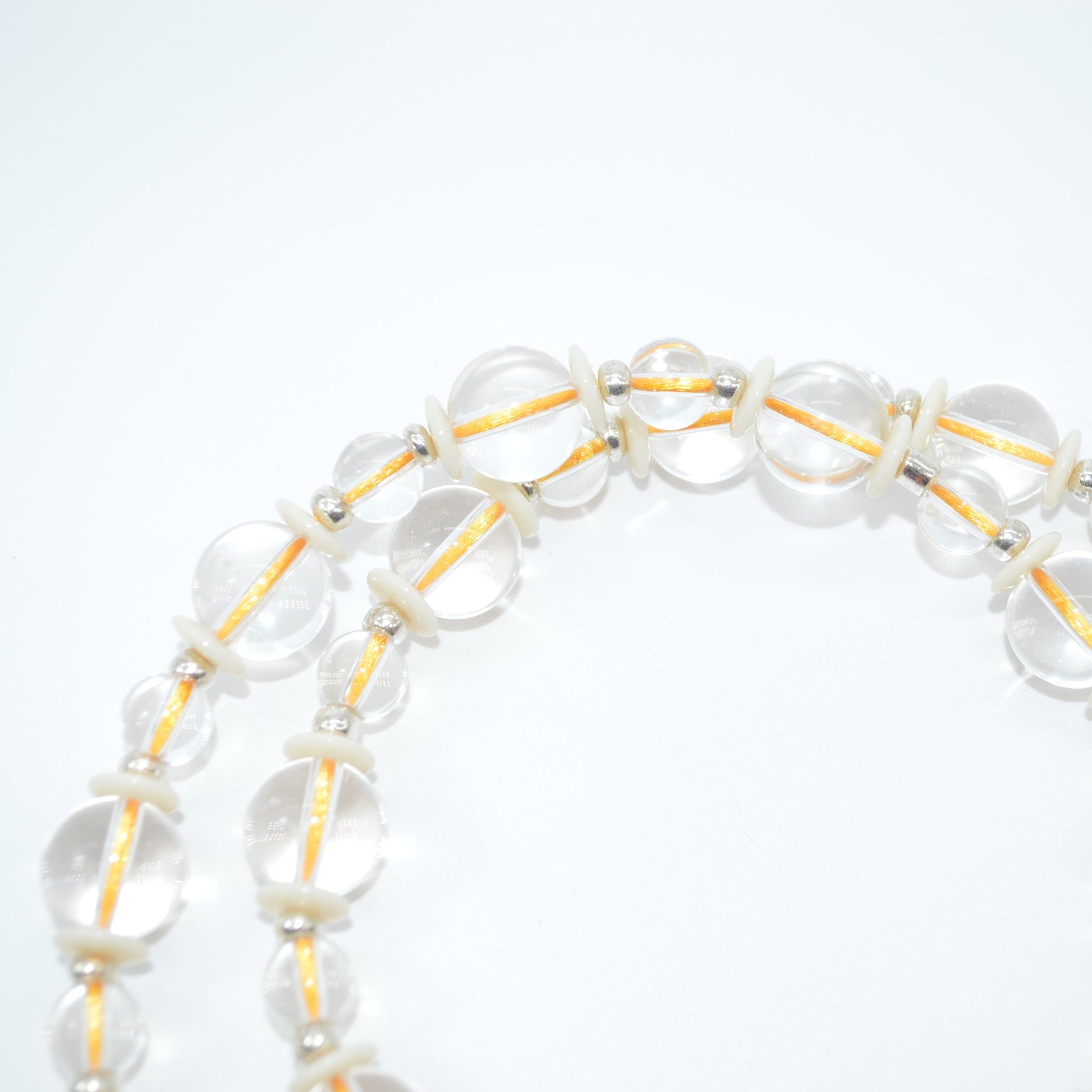 Clear beaded bracelet with gold accents on a white background