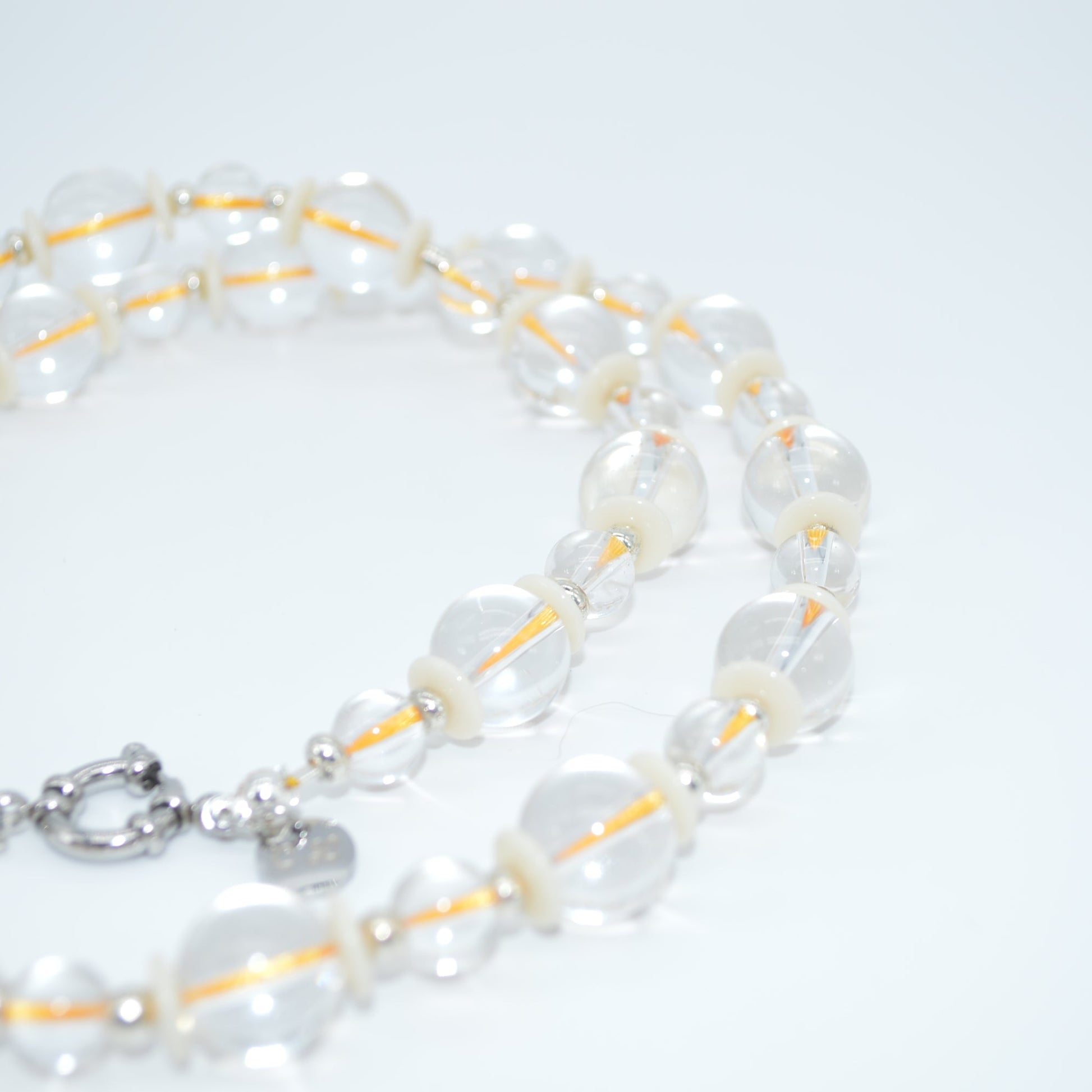 Pearl necklace with a silver clasp on a light gray background