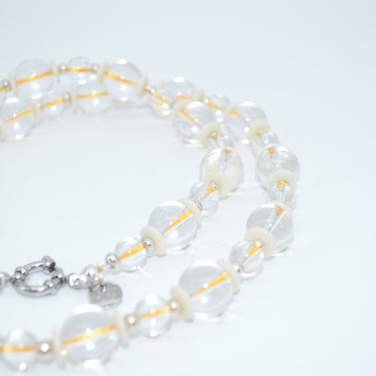 Pearl necklace with a silver clasp on a light gray background