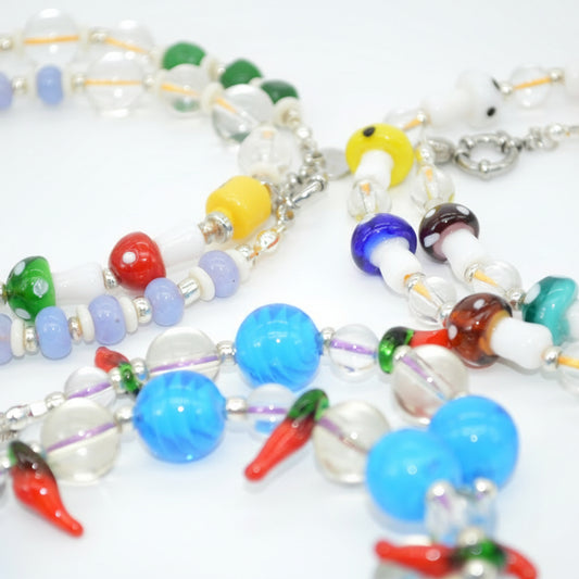 Colorful beaded necklace with various beads on a white background