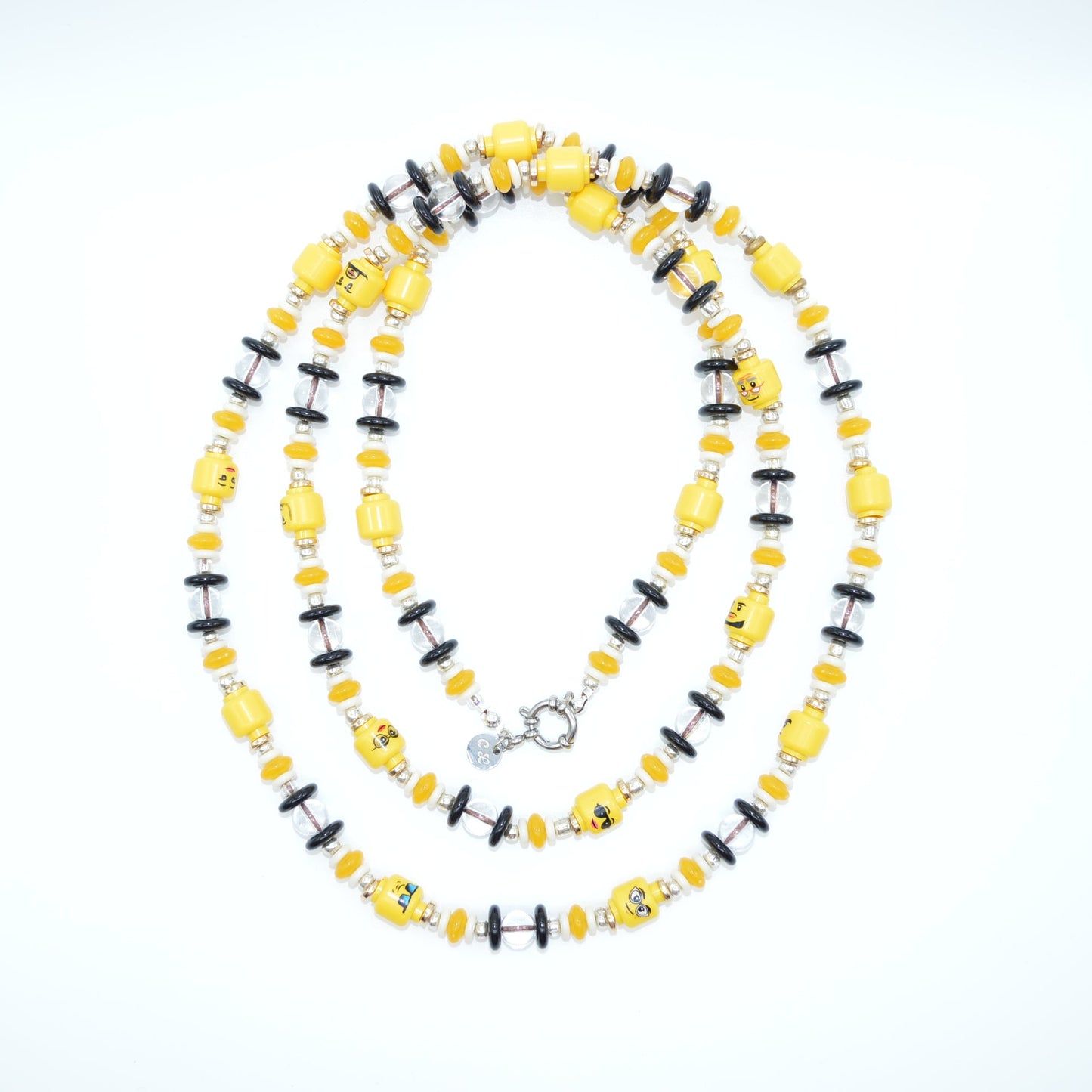 Necklace with yellow and black beads on a light gray background