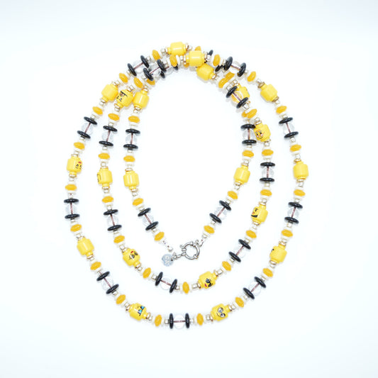 Necklace with yellow and black beads on a light gray background