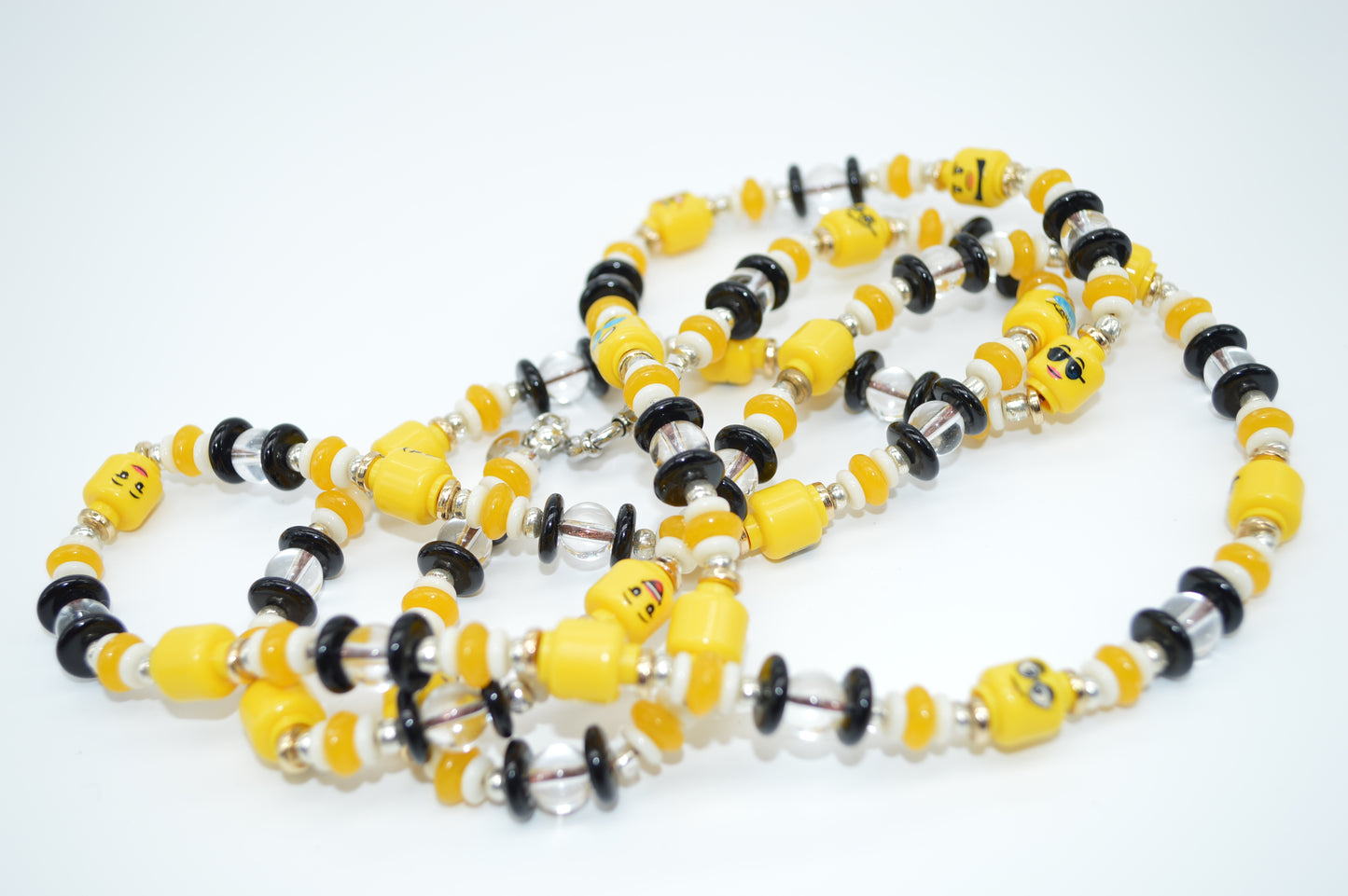 Necklace with yellow, black, and silver beads on a white background