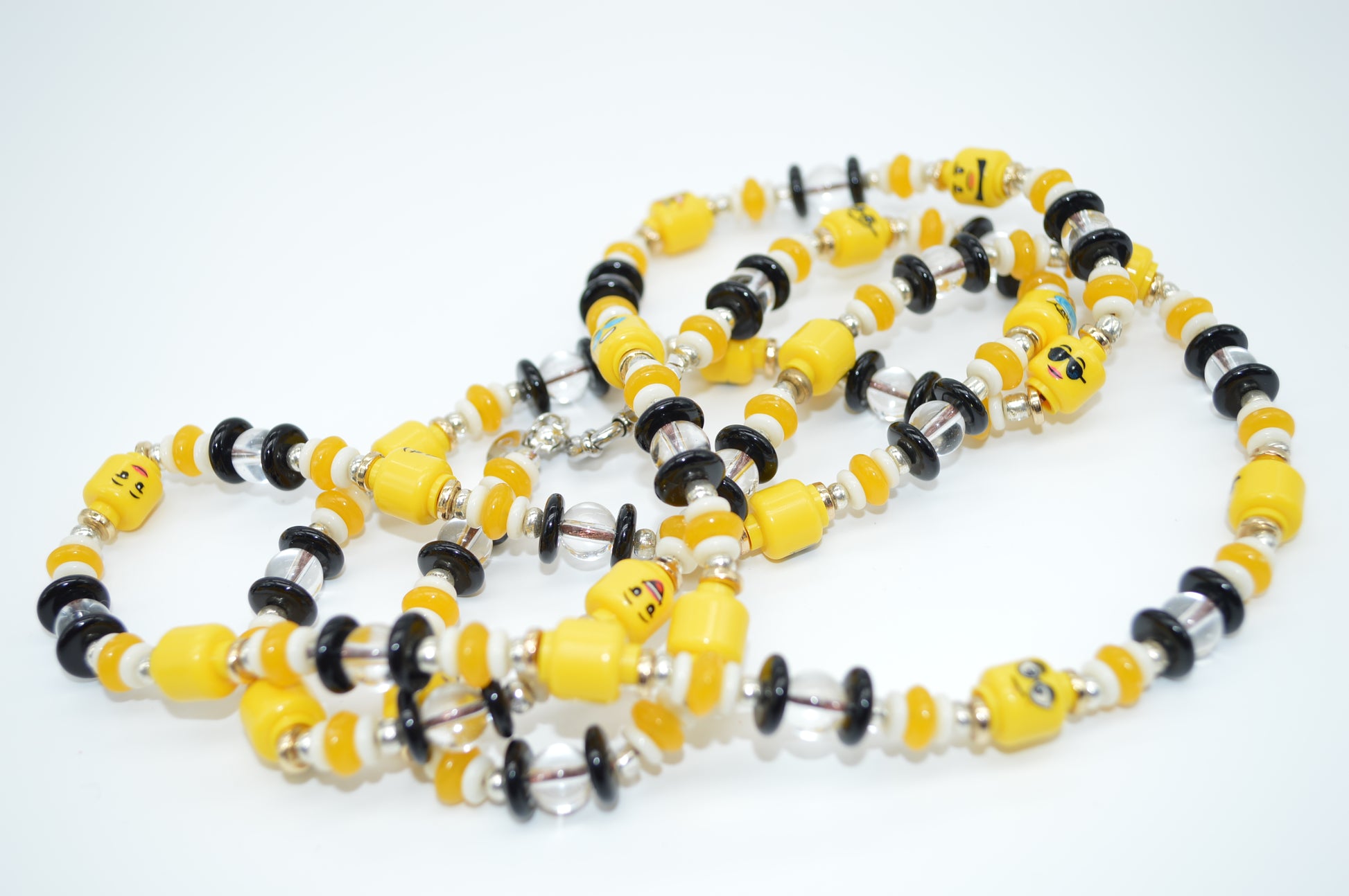 Necklace with yellow, black, and silver beads on a white background