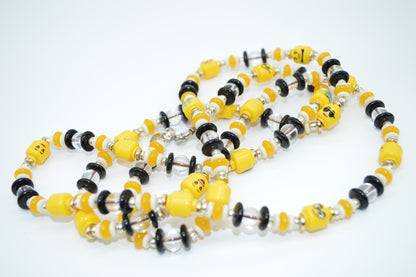 Necklace with yellow, black, and silver beads on a white background