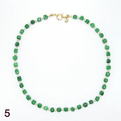 Green beaded necklace with a gold clasp on a white background