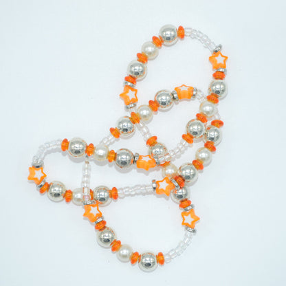 Necklace with white, orange, and silver beads on a light gray background