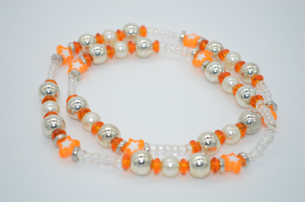 Beaded necklace with white, orange, and silver beads on a light gray background