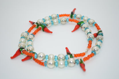 Necklace with red chili pepper-shaped beads on a white background