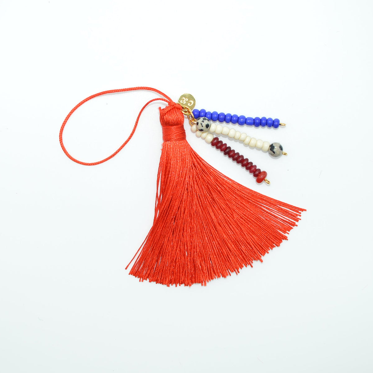 Red tassel with colorful beads on a white background