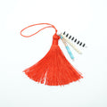 Red tassel with a small notebook on a white background