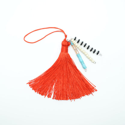 Red tassel with a small notebook on a white background