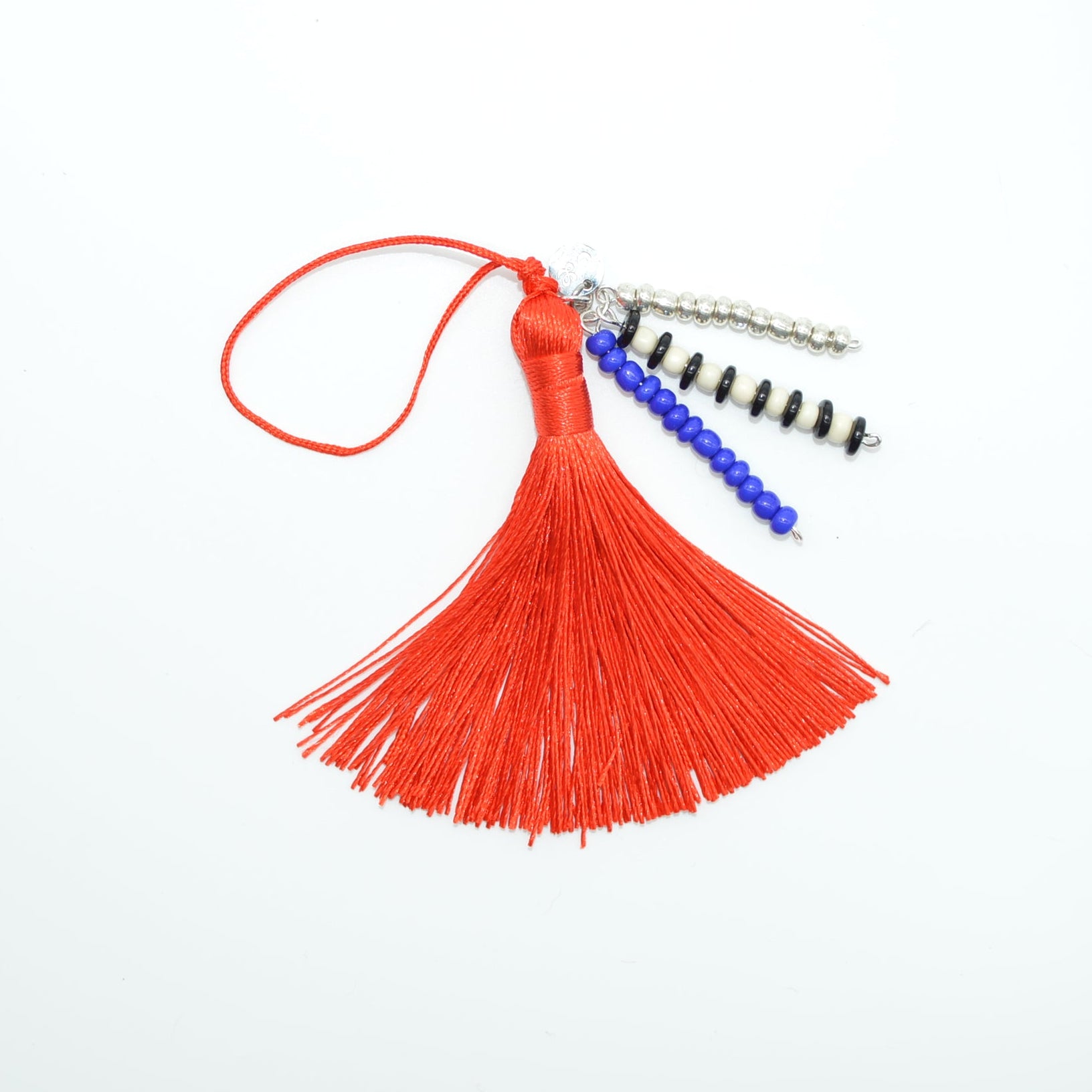 Red tassel with blue and black beads on a white background