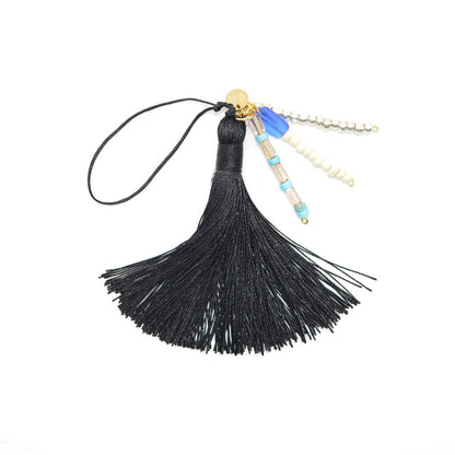 Black tassel charm with beads on a white background