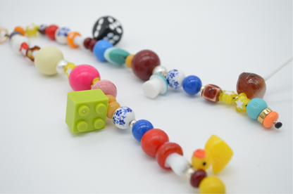 Colorful beaded necklace with various shapes and colors on a white background