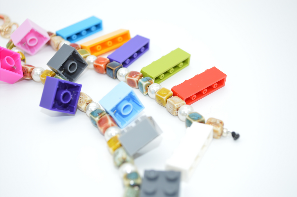 Colorful necklace with LEGO brick elements on a white background