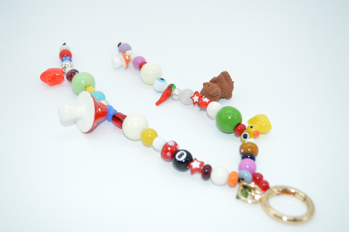 Colorful beaded keychain with various charms on a white background
