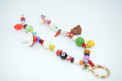 Colorful beaded keychain with various charms on a white background