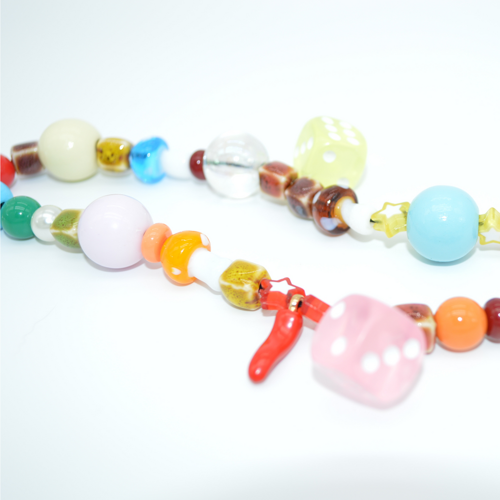 Colorful beaded necklace with various shapes on a white background