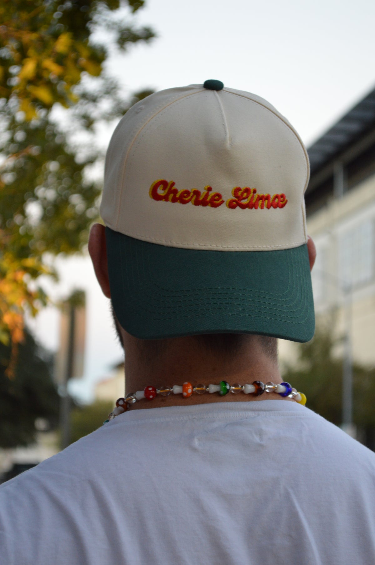 Person holding a cap with 'Charlie Pierce' branding outdoors