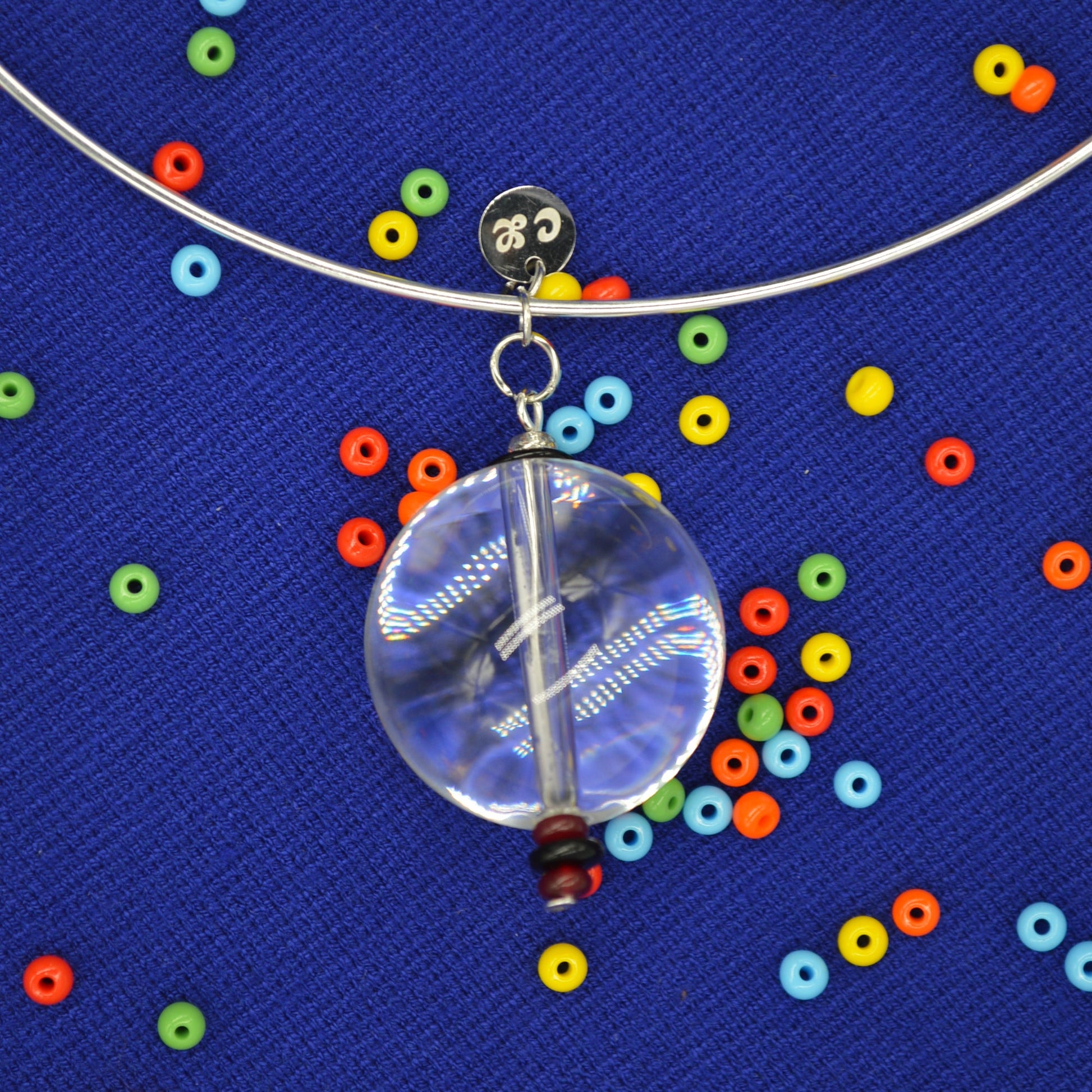 Clear glass orb with colorful beads on a blue textured background